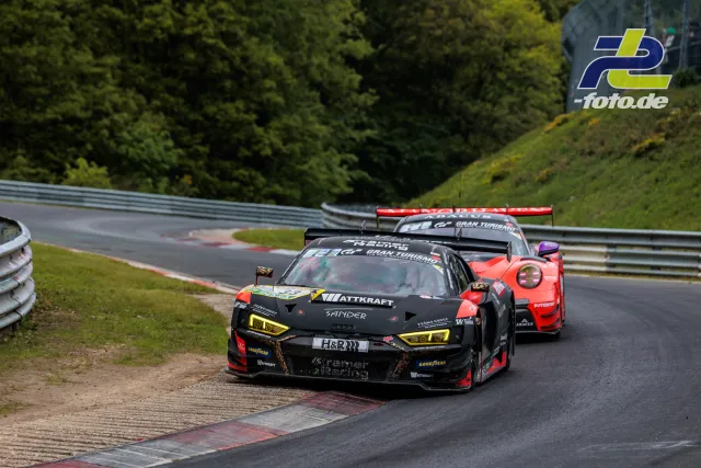 Zwei GT3-Rennwagen in der Kurve auf der Nordschleife während des 24h-Rennens. Im Vordergrund ein Audi R8, dahinter ein Porsche 911.