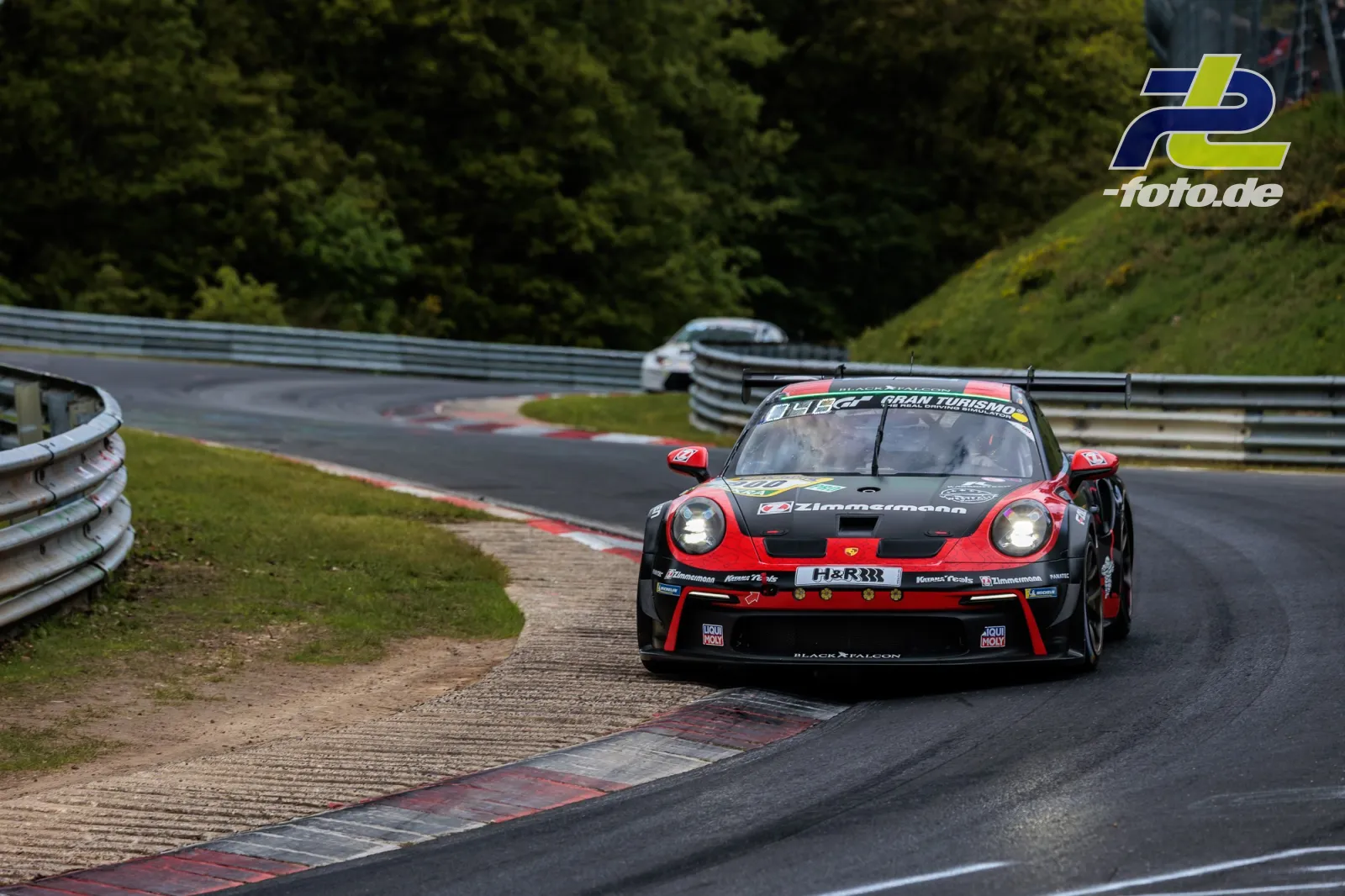 Porsche 911 GT3 Cup (992) #900 in Kurve auf Nordschleife beim 24h-Rennen Nürburgring, Fahrzeug nutzt Randstein.