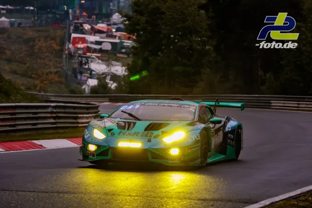 Lamborghini Huracán GT3 mit Startnummer 7 in türkisfarbener Lackierung mit eingeschalteten Scheinwerfern auf der Nordschleife.