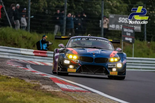 BMW Z4 GT3 mit eingeschalteten Scheinwerfern auf der Nordschleife während des 24h-Rennens am Nürburgring.