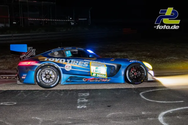 Blauer Mercedes-AMG GT3 mit Toyo Tires-Lackierung nachts an der Boxengasse auf dem Nürburgring während des 24h-Rennens.