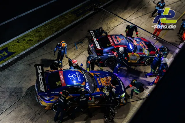 Nächtlicher Boxenstopp zweier GT3-Fahrzeuge in der Boxengasse des Nürburgrings, Vogelperspektive auf die Teams bei der Arbeit.