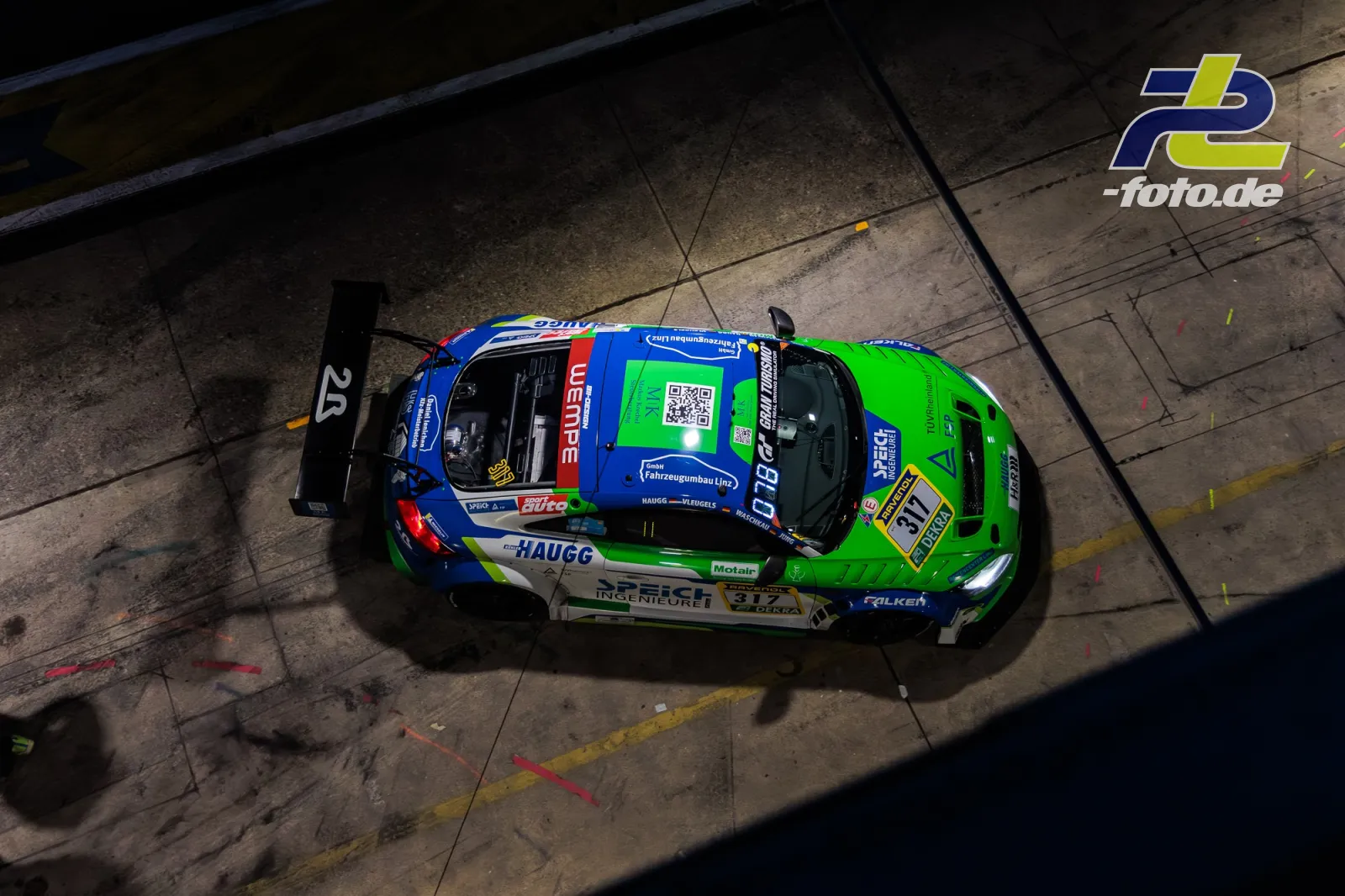 Audi TTs in blau-grüner Lackierung in der Boxengasse beim 24h-Rennen Nürburgring, Vogelperspektive bei Nacht.