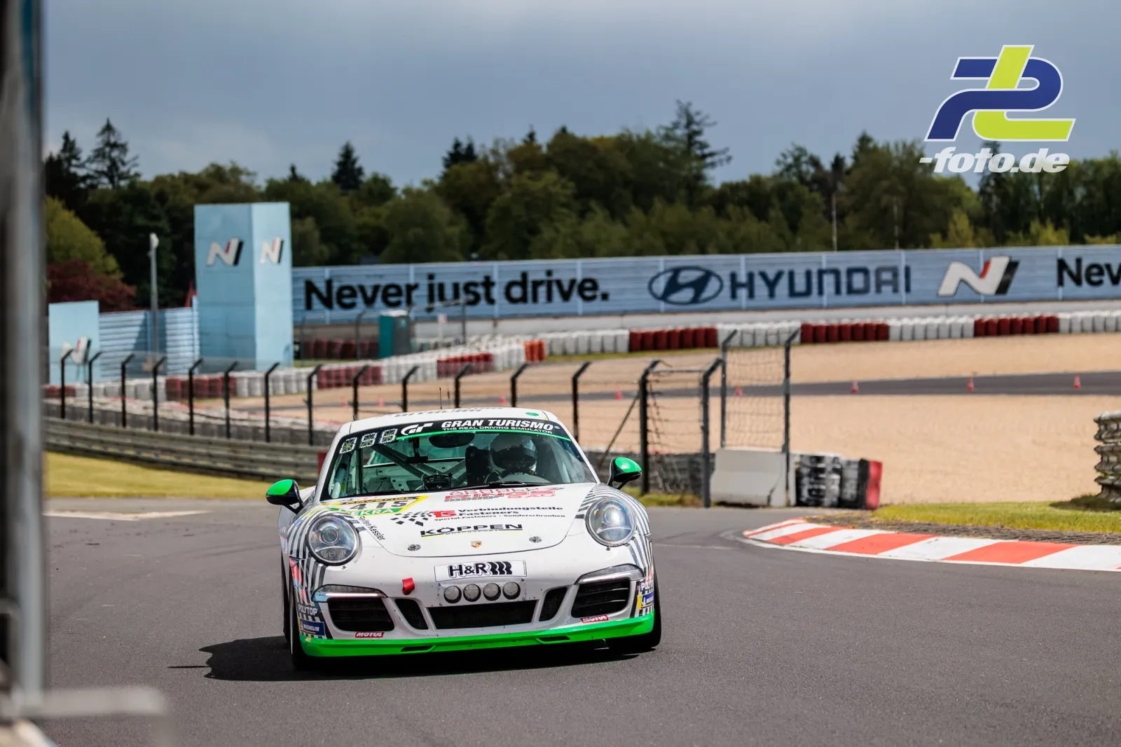 Weißer Porsche 911 Carrera mit grünen Akzenten im Qualifying zum ADAC RAVENOL 24h Nürburgring 2026 in der Kurve.