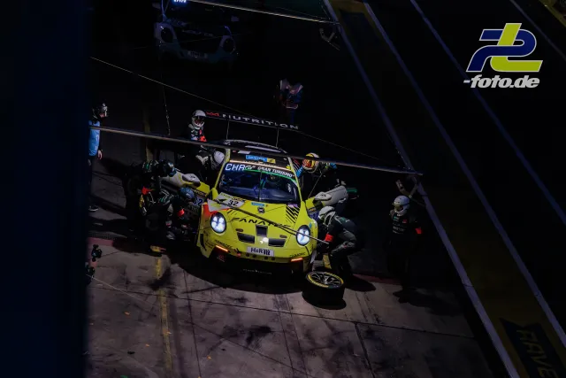 Porsche im Boxenstopp bei Nacht während des 24h-Rennens am Nürburgring, Mechaniker tanken und wechseln die Reifen