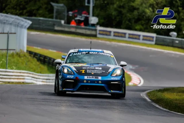 Porsche 718 Cayman GT4 in blau-schwarz-weißer Lackierung auf der Nordschleife während des Qualifyings zum 24h-Rennen Nürburgring.