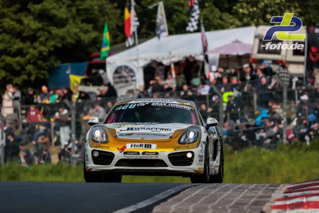Porsche Cayman am Nürburgring mit Zuschauern im Hintergrund während des 24h-Rennens