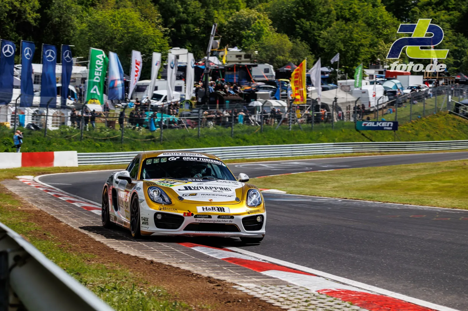Porsche Cayman in weiß-gelber Lackierung in der Nordschleifen-Kurve während des Qualifyings zum 24h-Rennen am Nürburgring