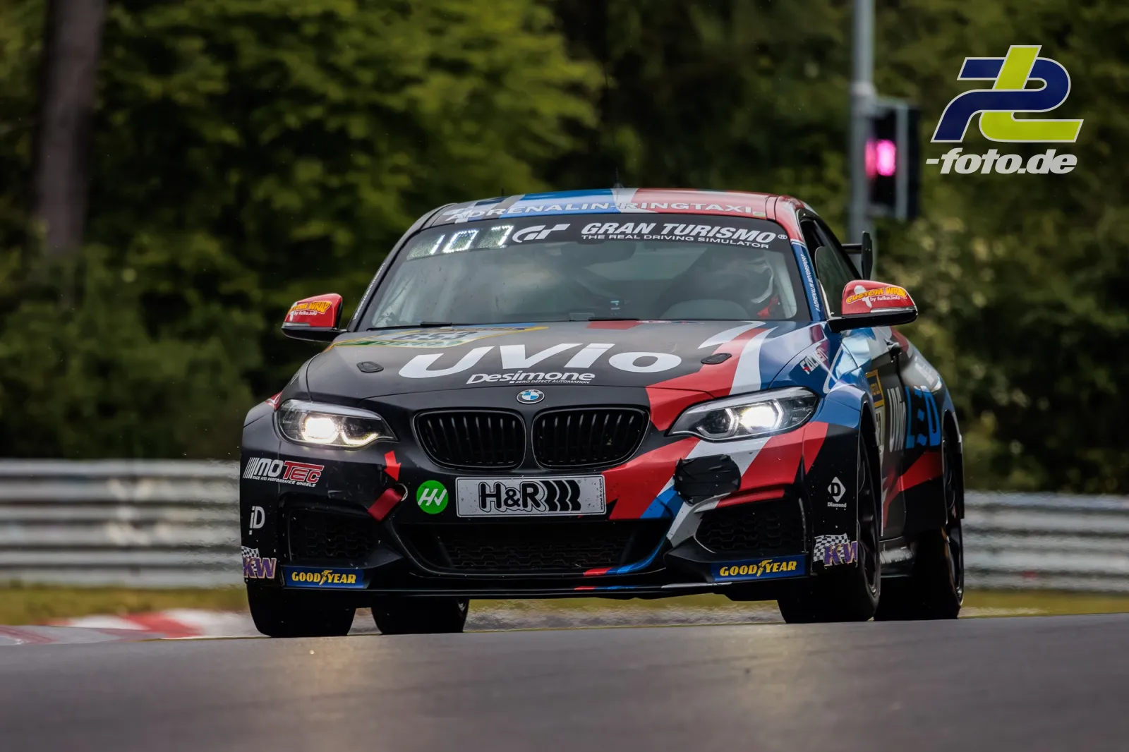 BMW M240i Cup mit bunter Lackierung in Frontansicht auf der Nordschleife während des 24h-Rennens am Nürburgring.