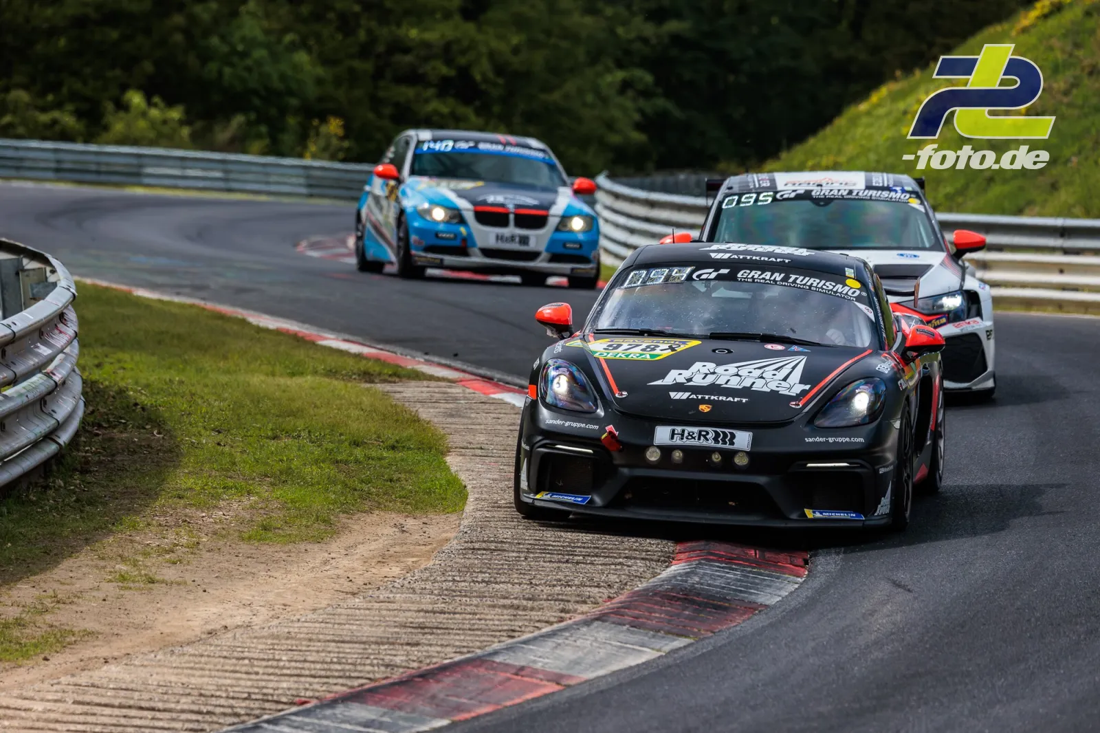 Porsche 718 Cayman GT4 Clubsport #978 von KKrämer Racing in Kurve auf Nordschleife beim 24h-Rennen Nürburgring, gefolgt von zwei Konkurrenten.
