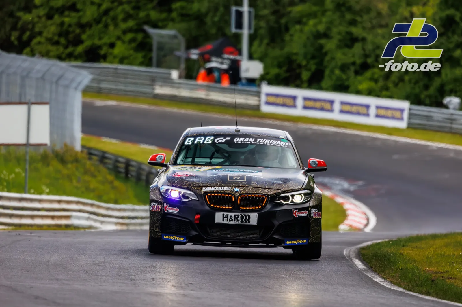 BMW Rennwagen mit violett-schwarzer Lackierung und roten Spiegelkappen auf der Nordschleife des Nürburgrings während des Qualifyings.