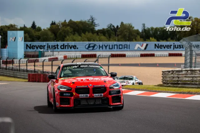 Roter BMW M4 GT4 im Qualifying auf der Nordschleife am Nürburgring, weitere Fahrzeuge im Hintergrund.