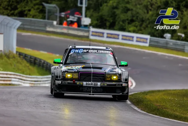 Schwarzer Mercedes-Klassiker mit grünen Spiegeln und gelben Scheinwerfern in einer Kurve der Nordschleife während des Qualifyings.