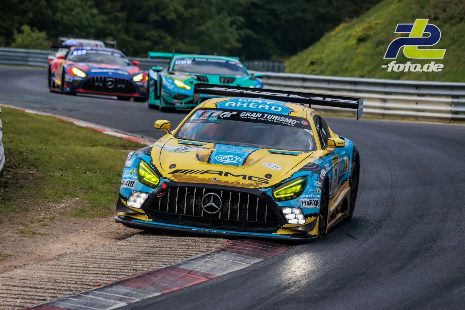 Drei GT3-Rennwagen im Verfolgerfeld auf der Nordschleife beim 24h-Rennen Nürburgring, angeführt von Mercedes-AMG GT3 in Gelb-Blau.