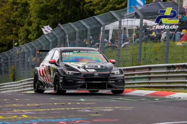 VW Golf GTI TCR mit schwarz-weißer Lackierung und roten Akzenten in Kurve auf der Nordschleife beim 24h-Rennen am Nürburgring.