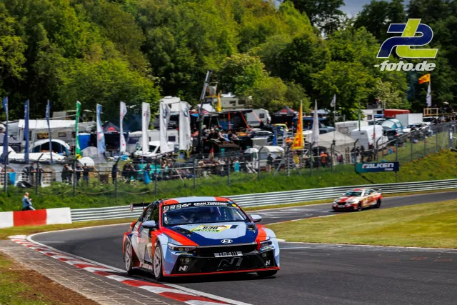 Hyundai Elantra N TCR Nr. 830 in einer Kurve auf der Nordschleife beim 24h-Rennen Qualifying, Paddock im Hintergrund
