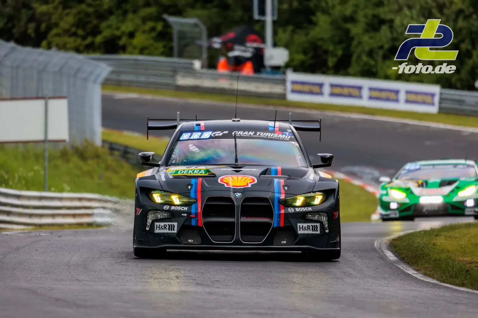 BMW M3 Touring 24h in schwarz während des Qualifyings auf nasser Strecke am Nürburgring, frontale Perspektive in einer Kurve.