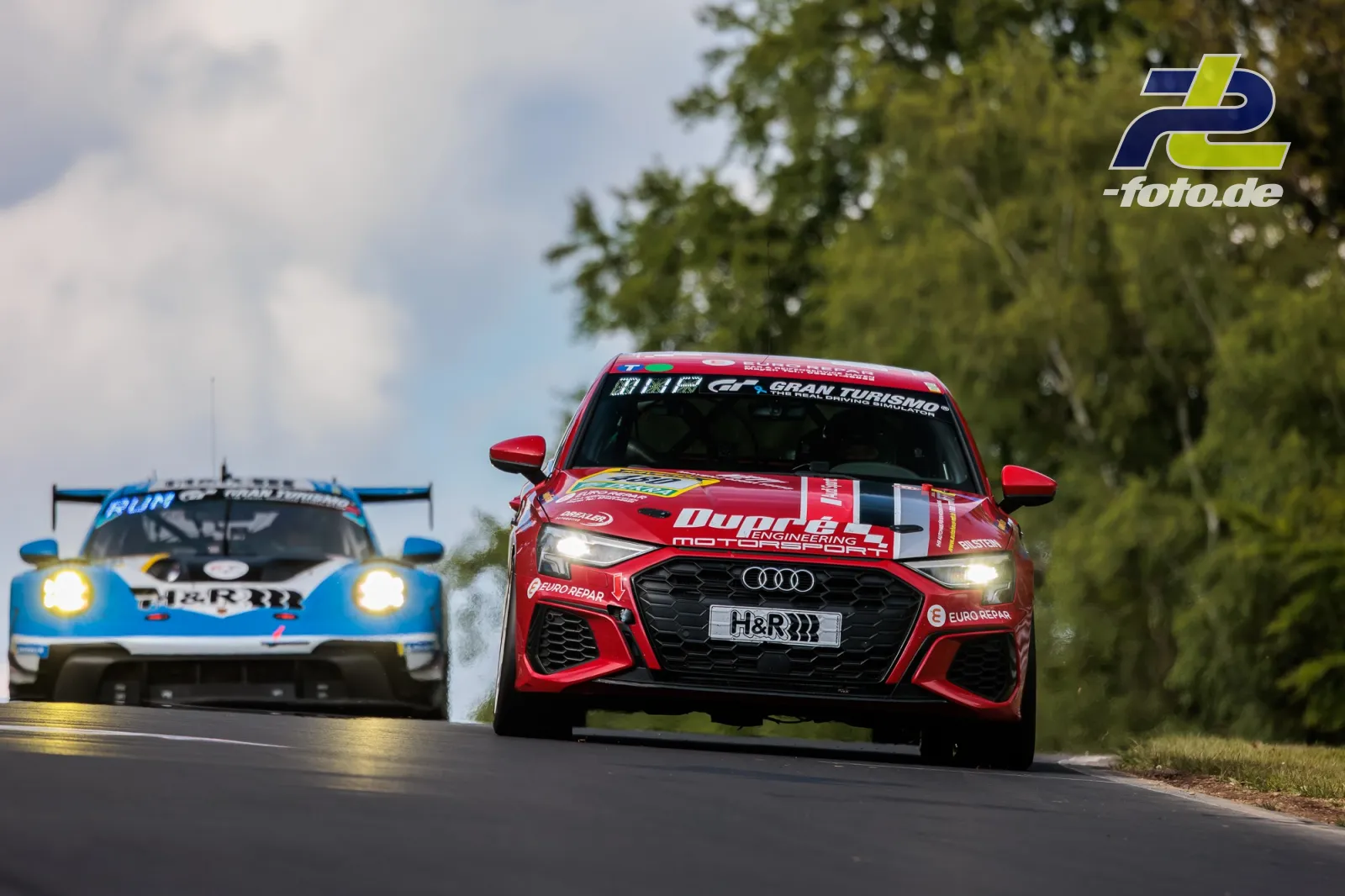 Roter Audi und blauer Porsche im Rennbetrieb während des 24h-Rennens Nürburgring auf der Nordschleife