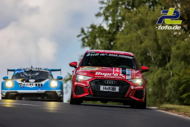 Roter Audi und blauer Porsche im Rennbetrieb während des 24h-Rennens Nürburgring auf der Nordschleife