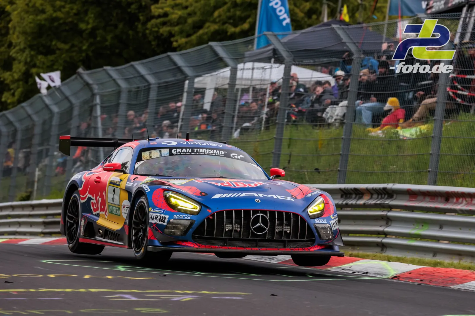 Mercedes-AMG GT3 von Winward Racing auf der Nürburgring-Nordschleife beim 24h-Rennen, Tribüne mit Zuschauern im Hintergrund.
