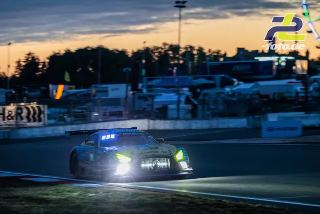 Mercedes-AMG in der Dämmerung auf dem Nürburgring mit leuchtenden Scheinwerfern.