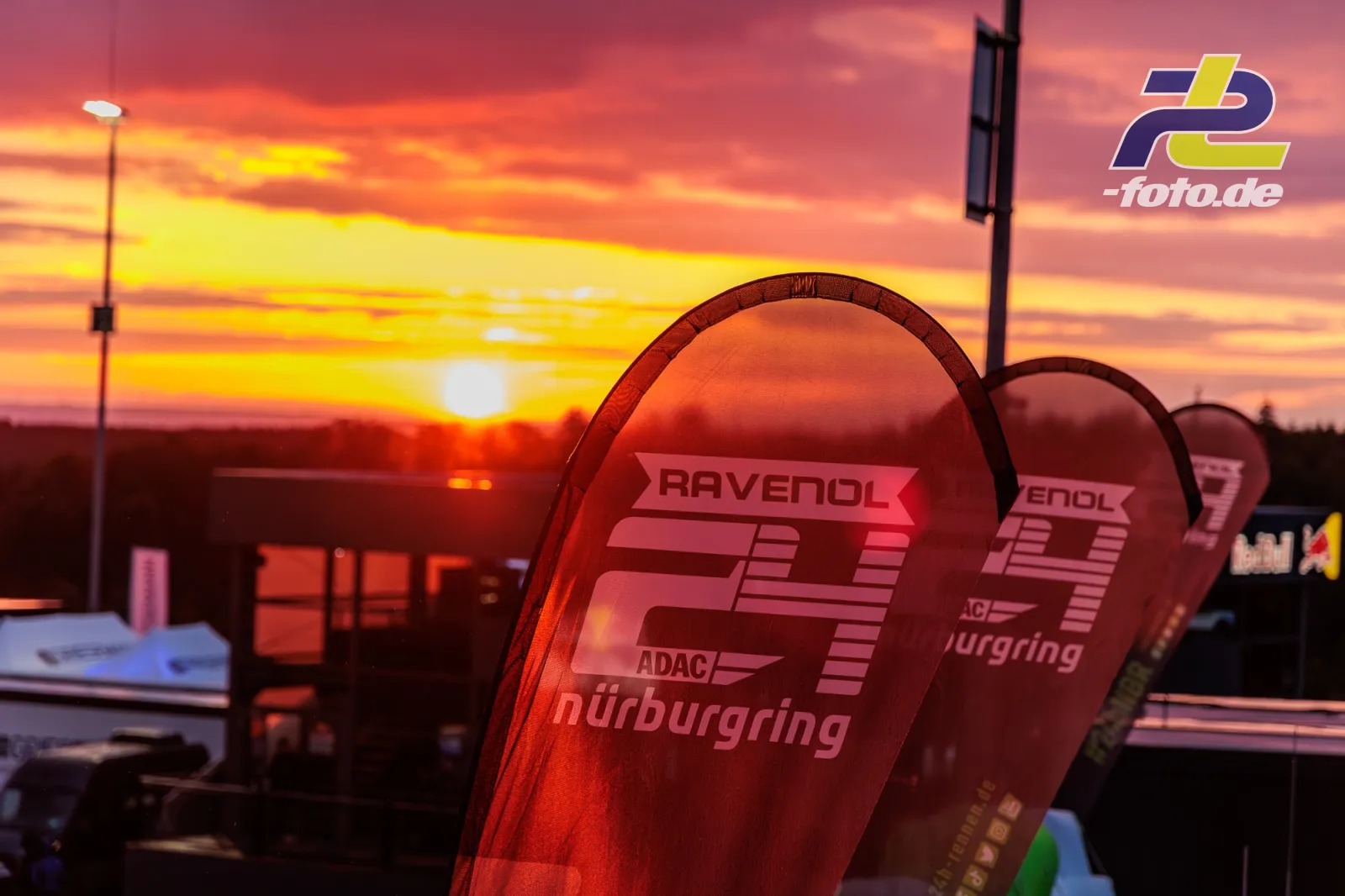 Siegerpokale mit RAVENOL- und Nürburgring-Logo bei Sonnenuntergang während des 24h-Rennens, dramatischer Abendhimmel im Hintergrund.