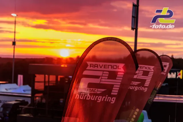 Siegerpokale mit RAVENOL- und Nürburgring-Logo bei Sonnenuntergang während des 24h-Rennens, dramatischer Abendhimmel im Hintergrund.
