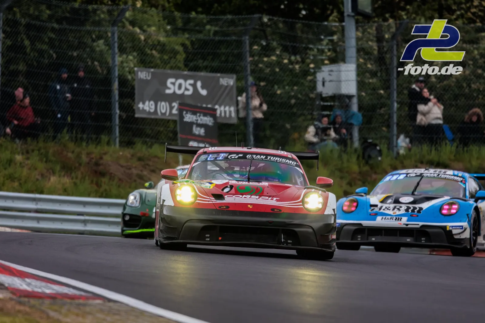 Drei GT3-Fahrzeuge auf der Nordschleife beim 24h-Rennen, angeführt von einem Porsche 911 GT3 R mit Licht