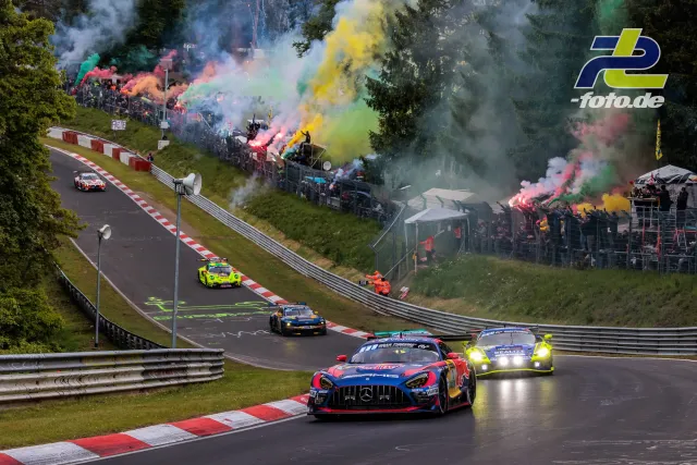 GT3-Fahrzeuge während der Formationsrunde beim 24h-Rennen Nürburgring, begleitet von buntem Rauch der Zuschauer an der Nordschleife.