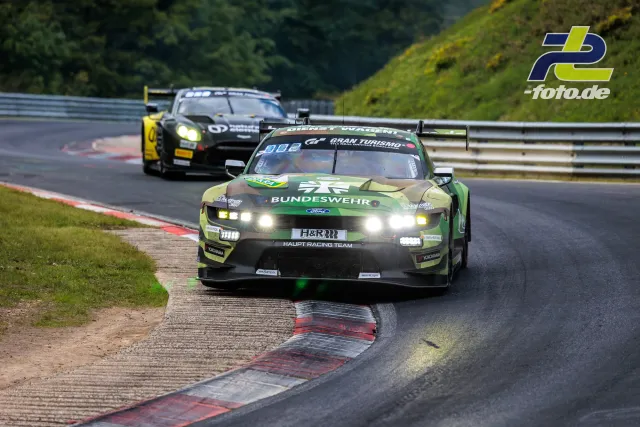 Ford Mustang GT3 EVO des HRT Ford Racing Teams in der Kurve beim 24h-Rennen am Nürburgring, gefolgt von einem weiteren GT3-Fahrzeug.