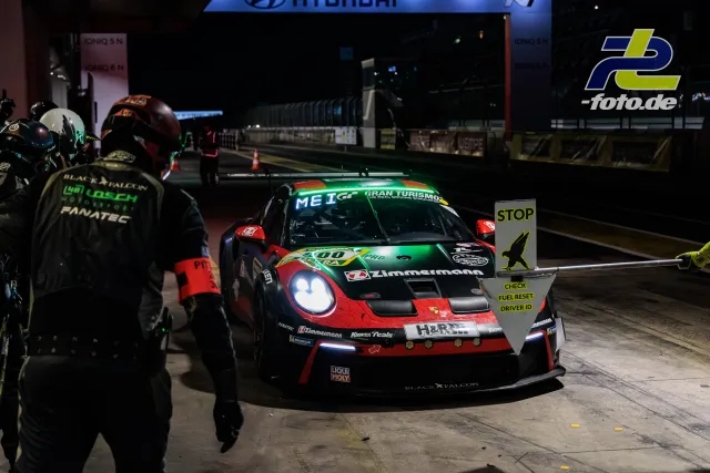 Porsche 911 GT3 R mit Startnummer 900 bei nächtlichem Boxenstopp während des 24h-Rennens am Nürburgring.