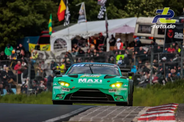 Türkis-grüner Aston Martin Vantage GT3 fährt auf der Nordschleife vor zahlreichen Zuschauern beim 24h-Rennen am Nürburgring.