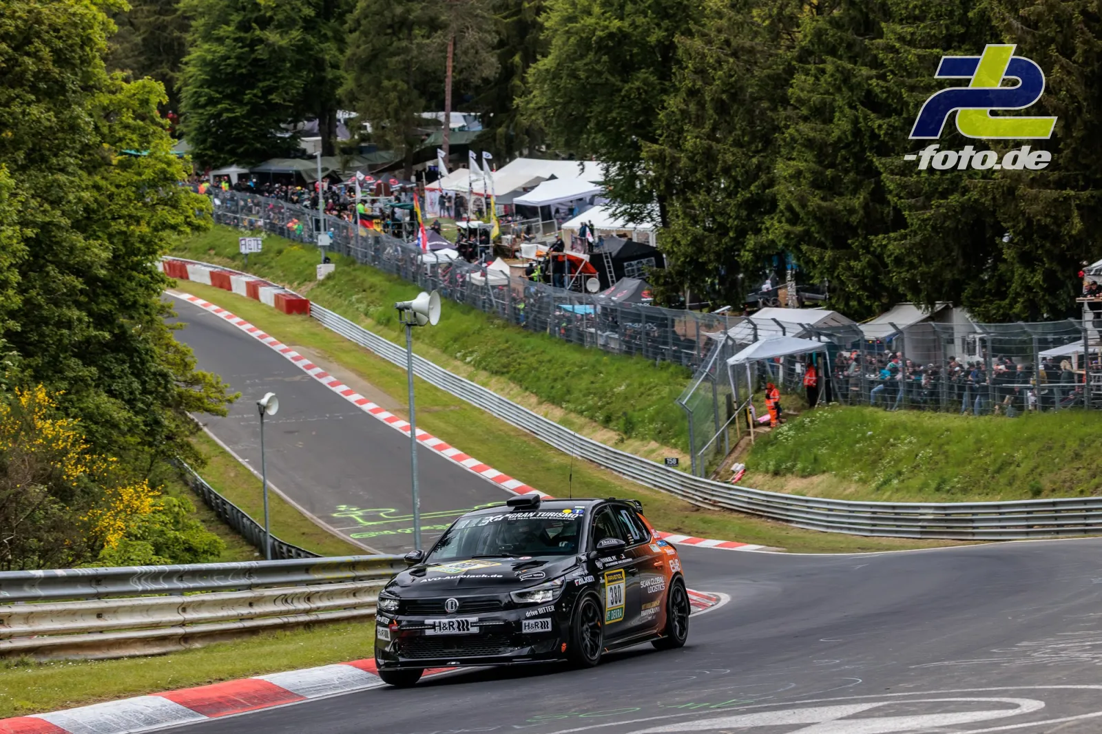 Opel Corsa GS Line 130* #380 in einer Kurve der Nürburgring-Nordschleife beim 24-Stunden-Rennen, Zuschauer an der Strecke.