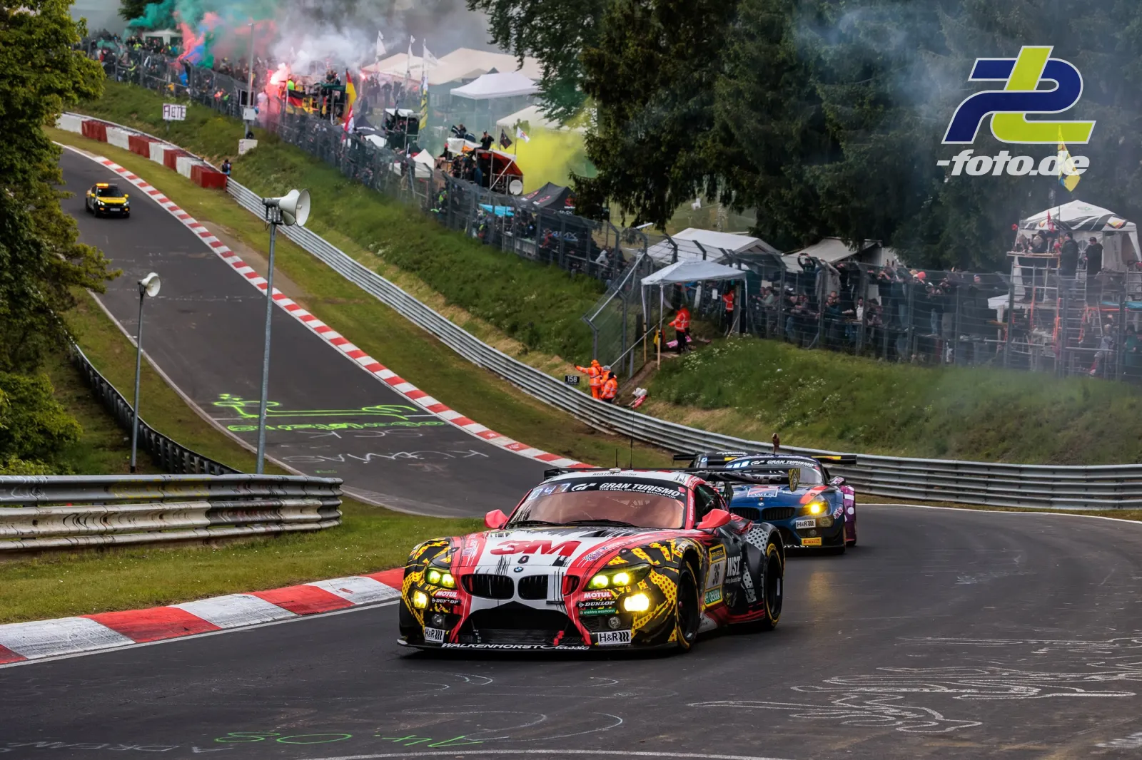 BMW E89 Z4 GT3 Startnummer 36 in der Formationsrunde zum 24h-Rennen Nürburgring, Zuschauer mit bunten Rauchfackeln am Streckenrand.