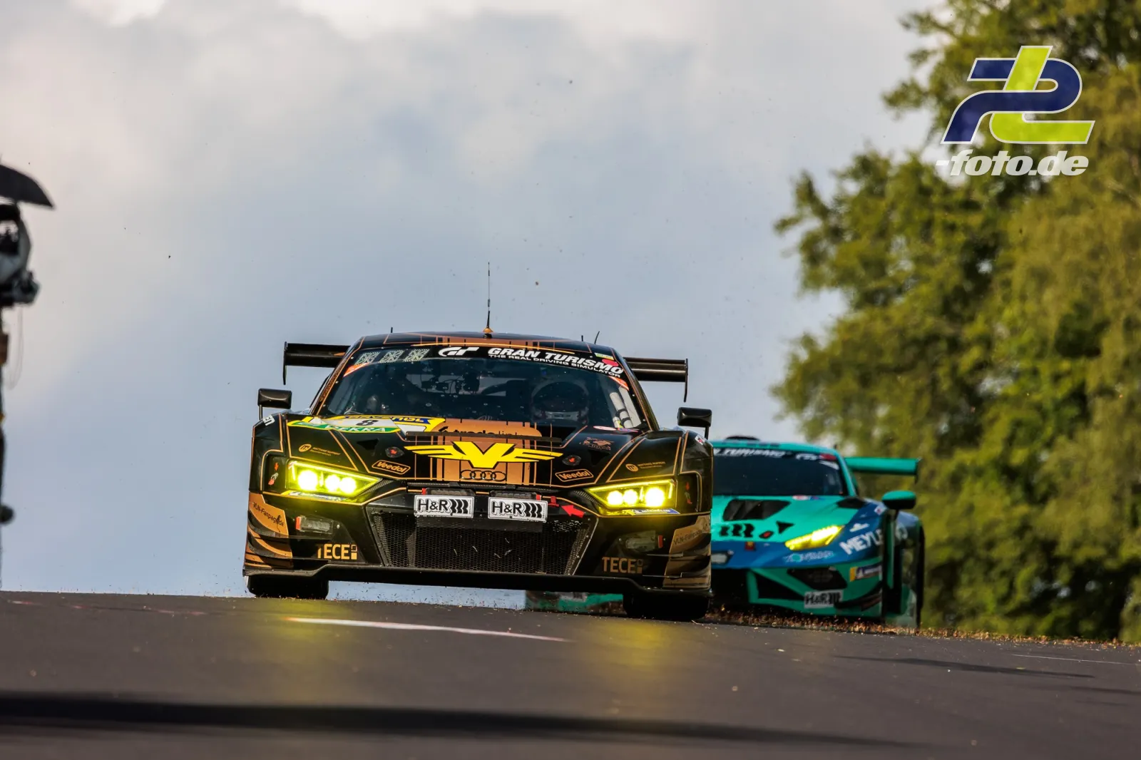 Audi R8 LMS GT3 evo II von JUTA Racing über eine Kuppe am Nürburgring, verfolgt von weiterem GT3-Fahrzeug während des 24h-Rennens