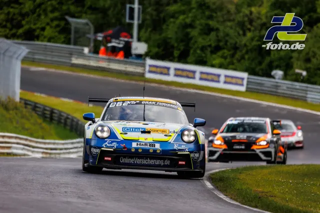 Porsche 911 GT3 Cup mit blau-gelber Lackierung auf der Nordschleife des Nürburgrings, gefolgt von zwei TCR-Fahrzeugen.