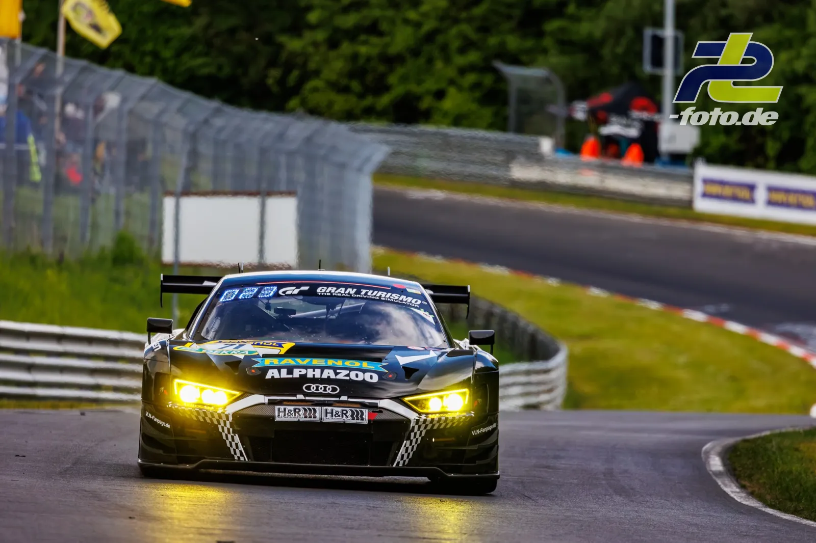 Audi R8 LMS GT3 mit gelben Scheinwerfern auf nasser Nordschleife während des Qualifyings zum 24h-Rennen am Nürburgring.