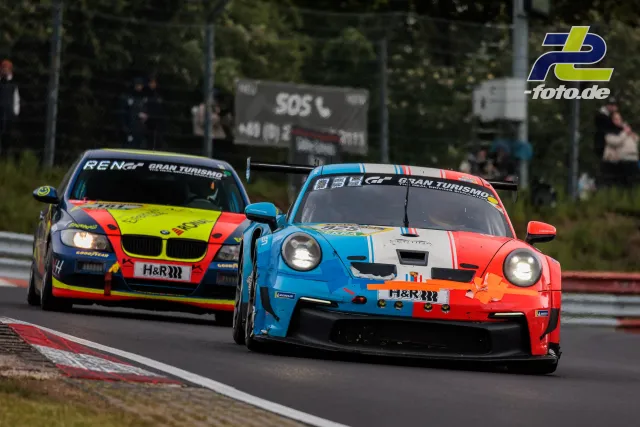 Zwei Rennwagen im Zweikampf während des 24h-Rennens auf dem Nürburgring, rechts Porsche in orange-blau-weiß, links BMW in neongelb-rot.