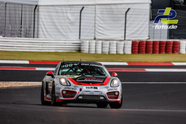 Porsche Cayman auf der Nordschleife während Qualifying 1 zum 24h-Rennen, weiß-rote Lackierung mit Sponsoren.