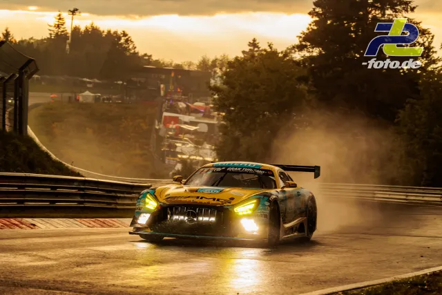 Mercedes-AMG GT3 im goldgelben Design auf nasser Nordschleife bei Gegenlicht während des Qualifyings zum 24h-Rennen am Nürburgring.