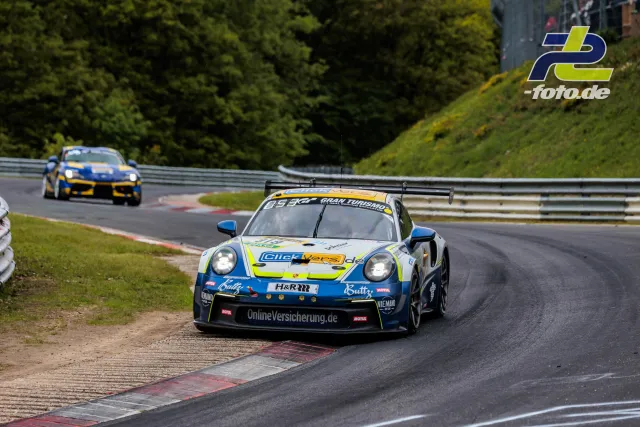 Porsche 911 GT3 Cup #934 in Kurve auf der Nürburgring-Nordschleife, gefolgt von weiterem Porsche während des 24h-Rennens.