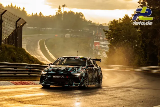 Rennwagen mit Tarnfolierung bei Gegenlicht auf der Nordschleife während des 24h-Rennens am Nürburgring