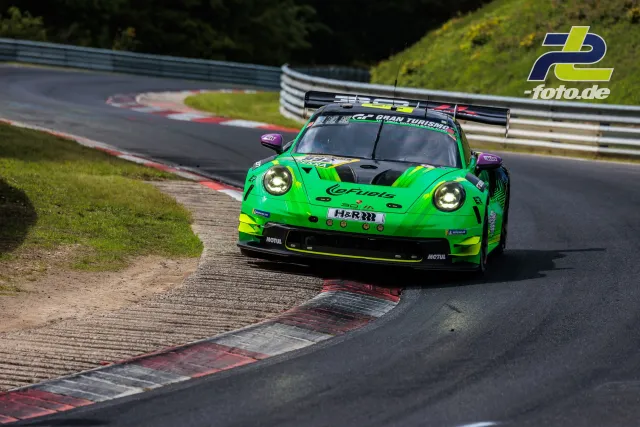 Porsche 911 GT3 R in neongrüner eFuels-Lackierung beim 24h-Rennen Nürburgring, nutzt Randstein in Kurve