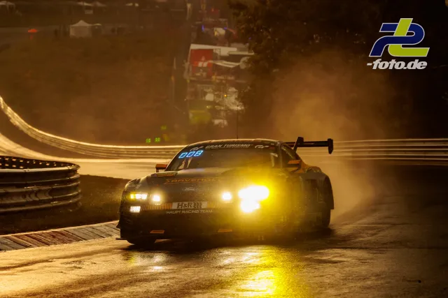 BMW M4 GT3 mit Startnummer 64 in abendlicher Kurvenpassage auf dem Nürburgring mit eingeschalteten Scheinwerfern.