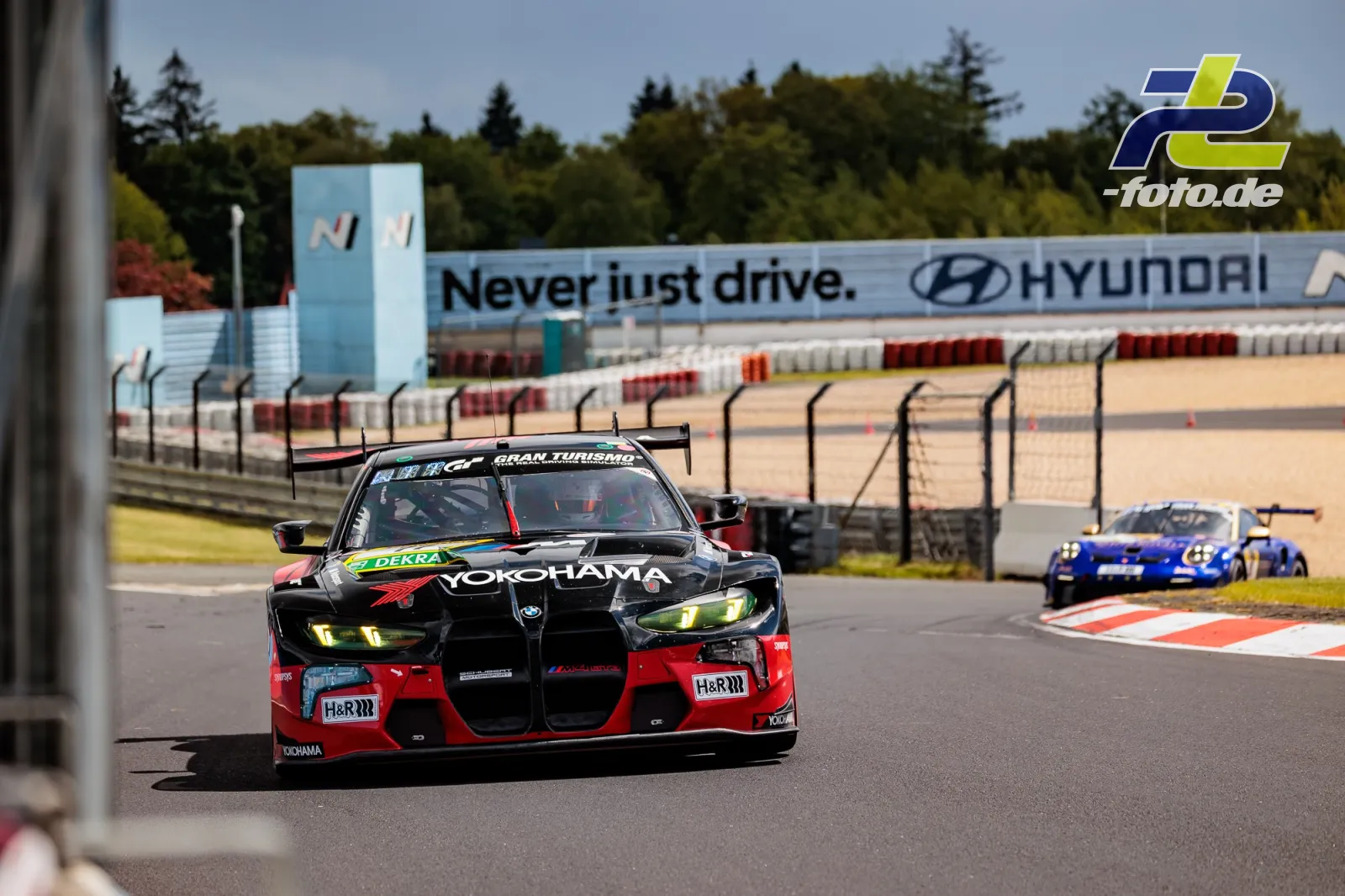 BMW im schwarz-roten Design mit Yokohama-Sponsoring beim Qualifying auf dem Nürburgring, gefolgt von einem blauen Porsche