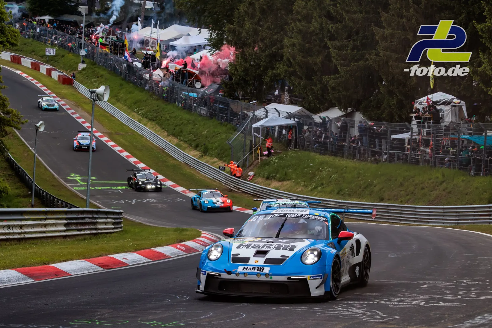 Porsche 911 GT3 Cup des Mühlner Motorsport in blau-weiß während der Formationsrunde auf der Nürburgring-Nordschleife mit Zuschauern.
