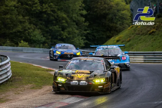 Drei GT3-Fahrzeuge in Kurve auf Nürburgring Nordschleife: Audi R8, Mercedes-AMG GT3 und Porsche 911 GT3 R mit Fangzaun im Hintergrund