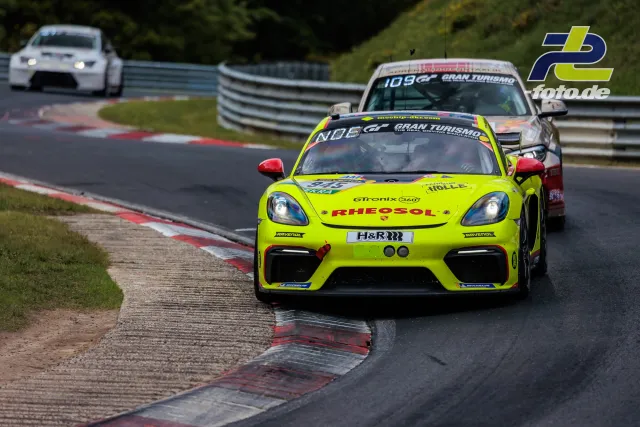 Porsche Cayman GT4 Nr. 103 auf der Nordschleife beim 24h-Rennen Nürburgring, verfolgt von zwei weiteren Fahrzeugen.