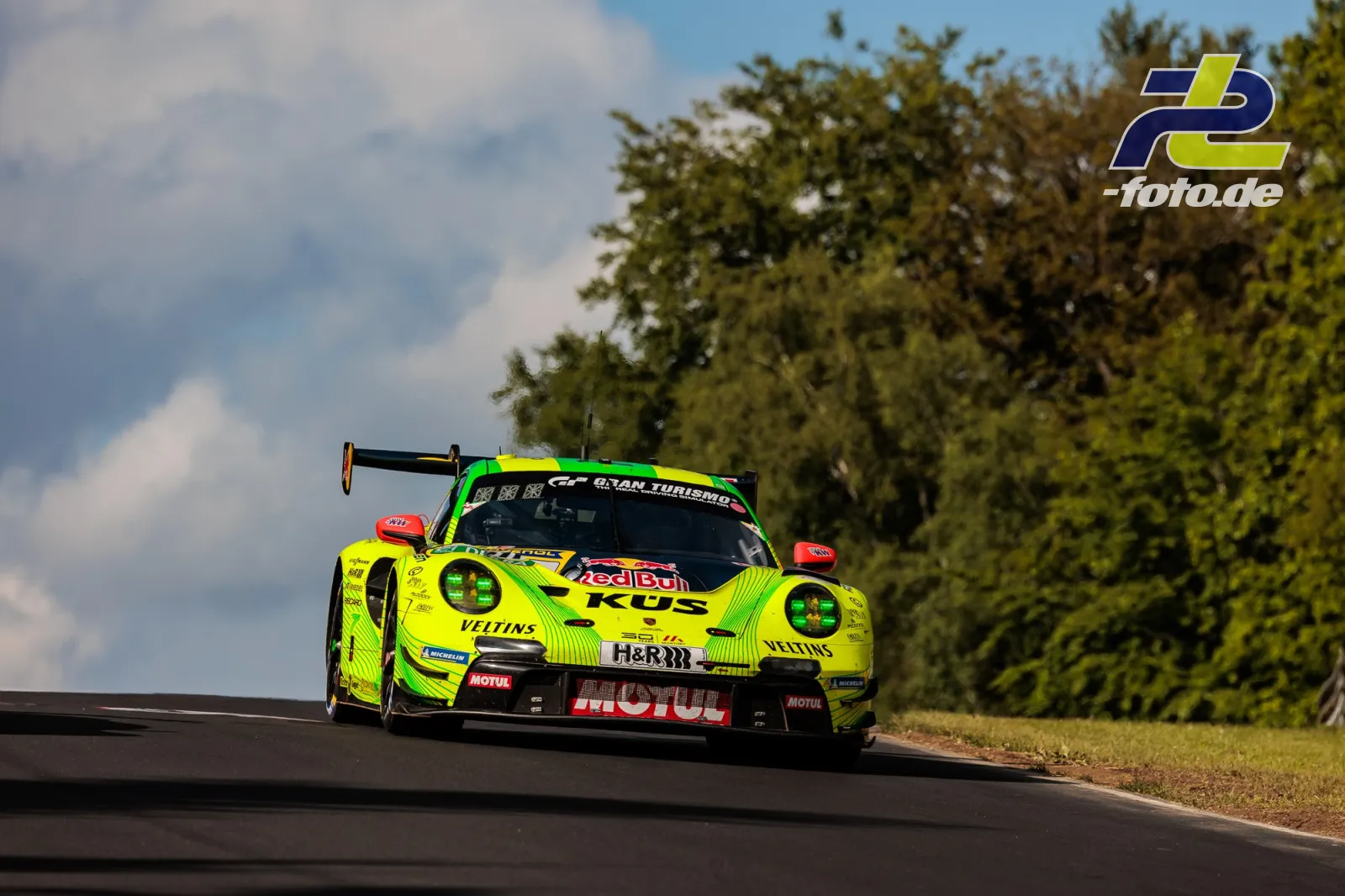Porsche 911 GT3 R in neongelb-grüner Lackierung während des 24h-Rennens am Nürburgring auf der Nordschleife.