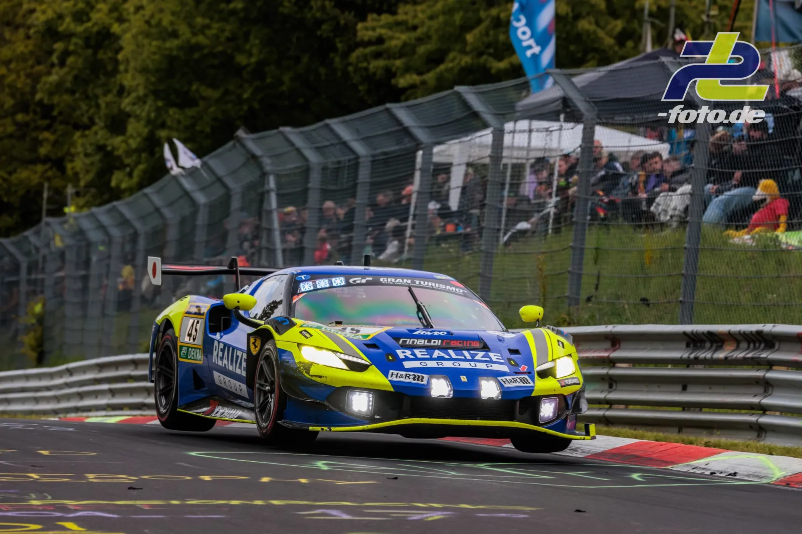 Ferrari 296 GT3 #45 von REALIZE KONDO RACING with Rinaldi in neongelb-blauer Lackierung auf der Nordschleife beim 24h-Rennen Nürburgring 2026.
